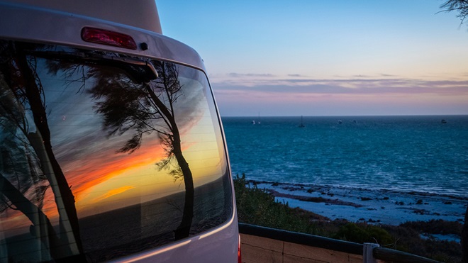reflection of sunset on rear window of campervan